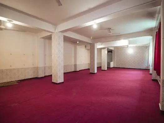Spacious carpeted yoga practice hall at Rishikesh Yog Kendra