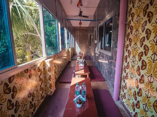 Dining area with bench seating and garden view at Rishikesh Yog Kendra